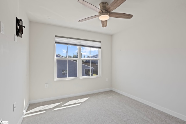 spare room with ceiling fan and light colored carpet