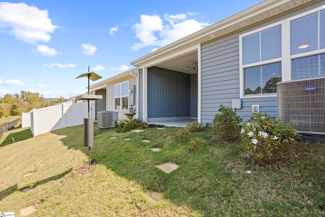 view of home's exterior with a lawn, central AC, and ceiling fan