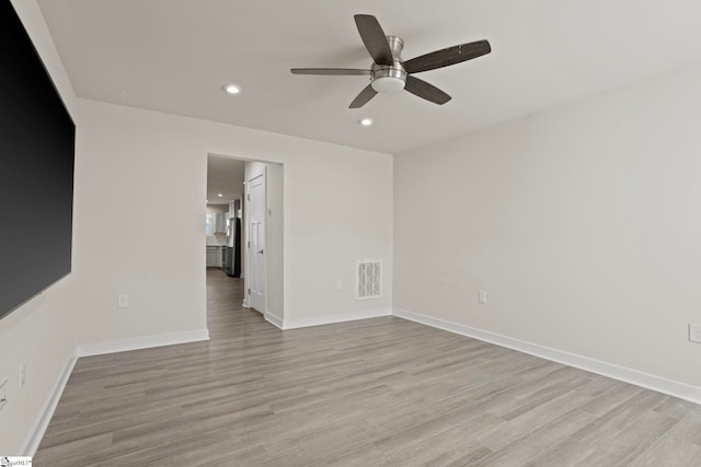 empty room featuring ceiling fan and light hardwood / wood-style flooring