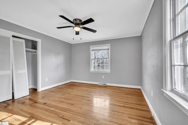 unfurnished bedroom featuring a closet, ceiling fan, light hardwood / wood-style flooring, and ornamental molding