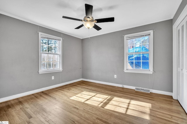 unfurnished bedroom featuring a closet, light hardwood / wood-style flooring, ceiling fan, and ornamental molding