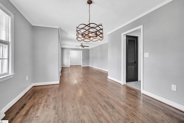 unfurnished dining area with hardwood / wood-style flooring, ceiling fan with notable chandelier, and ornamental molding