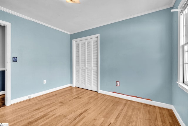 unfurnished bedroom with crown molding, light hardwood / wood-style flooring, and a closet