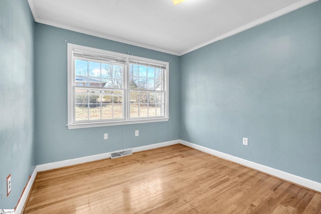 empty room with light hardwood / wood-style flooring and crown molding