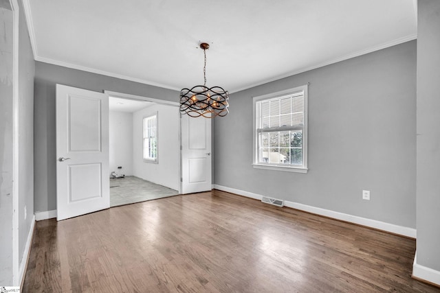 unfurnished dining area featuring a chandelier, hardwood / wood-style flooring, and crown molding