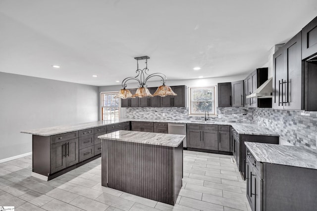 kitchen with dishwasher, pendant lighting, tasteful backsplash, and a kitchen island