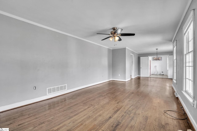 empty room featuring dark hardwood / wood-style floors, ceiling fan, and crown molding