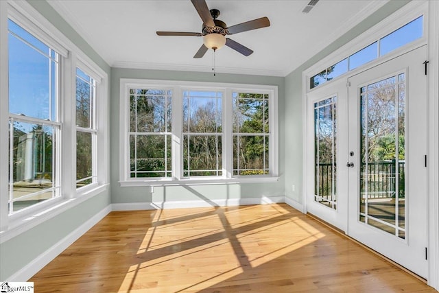 unfurnished sunroom with ceiling fan and french doors