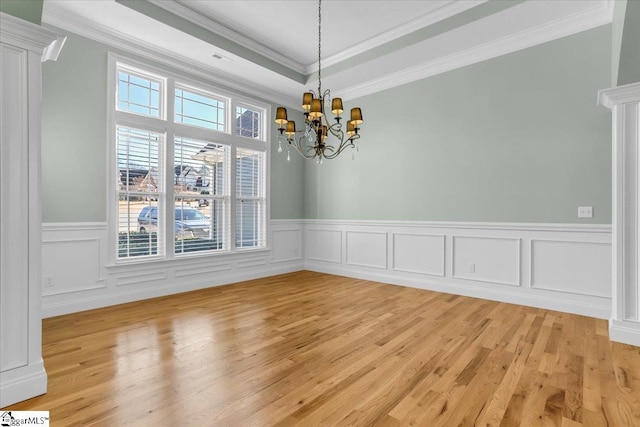 unfurnished dining area featuring crown molding, light hardwood / wood-style flooring, and an inviting chandelier