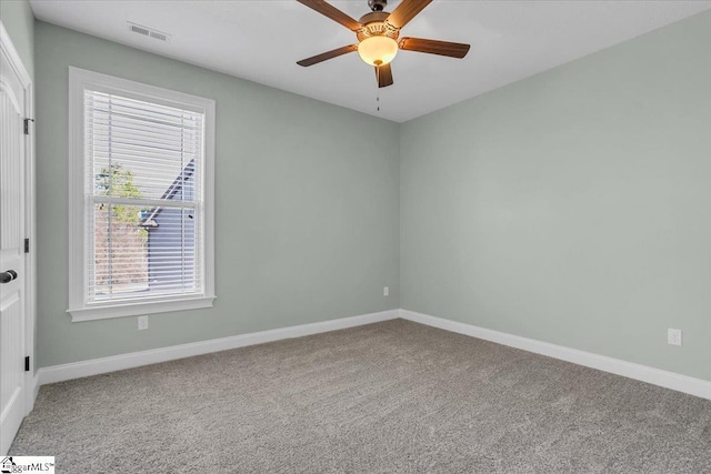 carpeted empty room featuring a wealth of natural light and ceiling fan