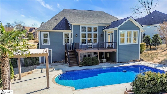 rear view of property featuring a pool side deck