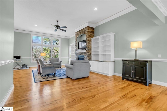 living room with ceiling fan, light hardwood / wood-style floors, a stone fireplace, and ornamental molding