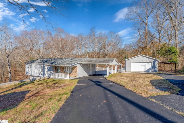 single story home with a front yard, a carport, covered porch, a garage, and an outdoor structure