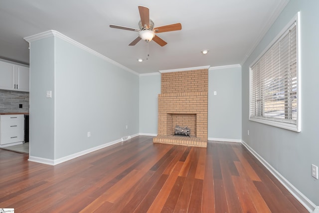 unfurnished living room featuring ceiling fan, dark hardwood / wood-style flooring, a fireplace, and crown molding