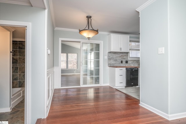 unfurnished dining area with plenty of natural light, dark hardwood / wood-style flooring, lofted ceiling, and ornamental molding