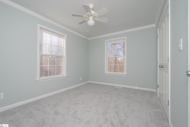 spare room featuring ceiling fan, light colored carpet, and ornamental molding