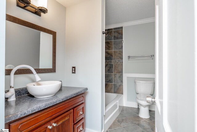 full bathroom featuring tile patterned floors, ornamental molding, vanity, a textured ceiling, and toilet