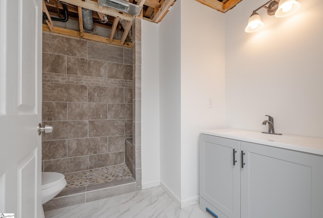 bathroom featuring vanity, toilet, and a tile shower