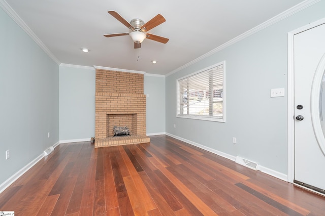 unfurnished living room with ornamental molding, a brick fireplace, ceiling fan, and dark wood-type flooring