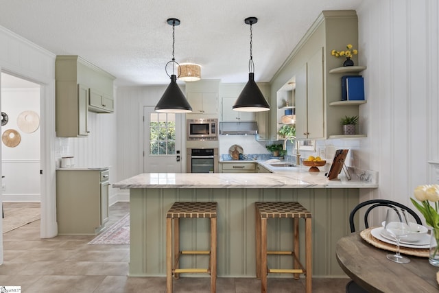 kitchen with sink, a breakfast bar, hanging light fixtures, stainless steel appliances, and kitchen peninsula