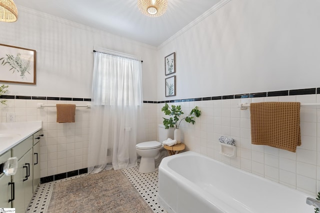 bathroom with toilet, tile walls, ornamental molding, vanity, and a bathtub