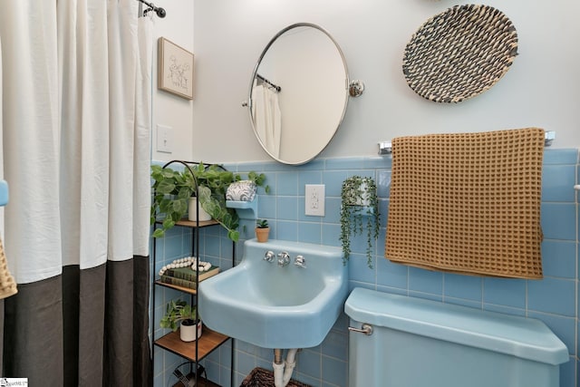 bathroom featuring sink, tile walls, and toilet