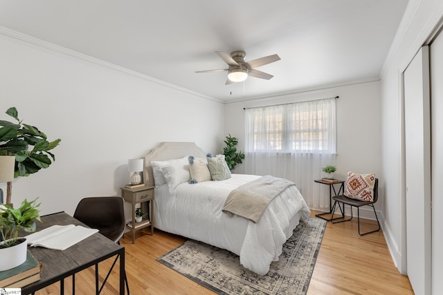 bedroom featuring ornamental molding, ceiling fan, and light wood-type flooring