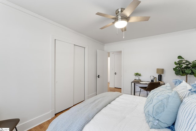 bedroom featuring crown molding, light hardwood / wood-style floors, a closet, and ceiling fan