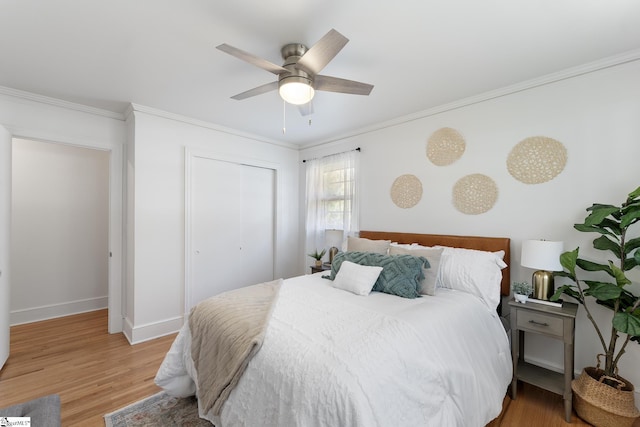 bedroom with light hardwood / wood-style flooring, ornamental molding, a closet, and ceiling fan