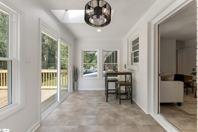 sunroom / solarium featuring plenty of natural light and a skylight