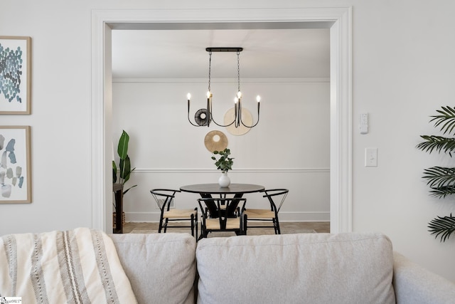 dining space featuring an inviting chandelier and ornamental molding