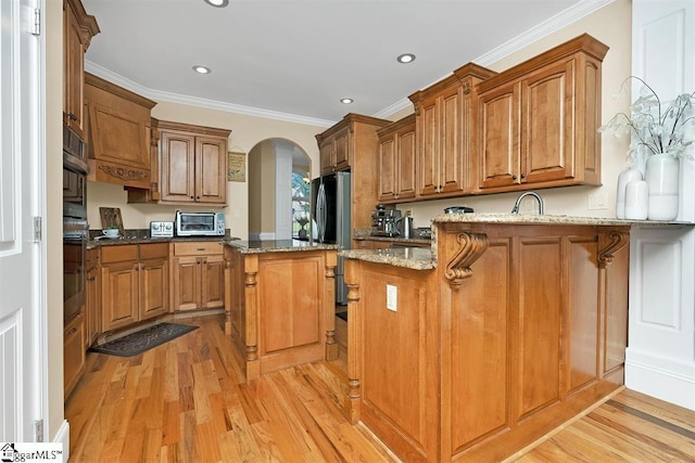 kitchen with kitchen peninsula, a breakfast bar, stone countertops, and light wood-type flooring