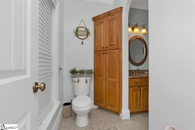 bathroom with tile patterned flooring, vanity, ornamental molding, and toilet