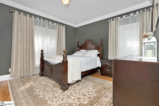 bedroom with crown molding and light hardwood / wood-style flooring