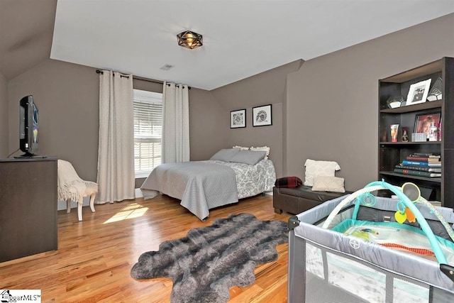 bedroom featuring hardwood / wood-style flooring and vaulted ceiling