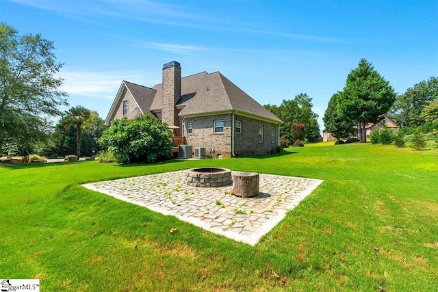 view of yard with central AC and a fire pit