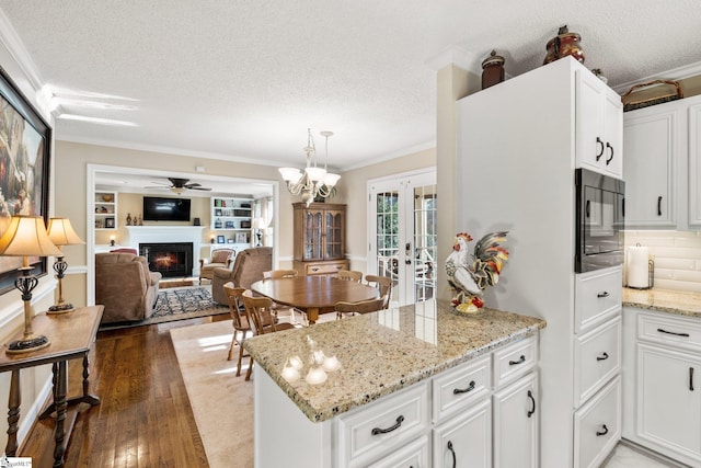 kitchen featuring white cabinets, a textured ceiling, and black microwave