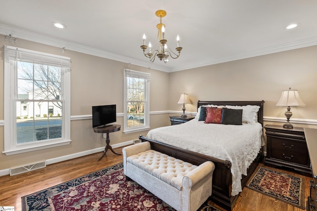 bedroom featuring hardwood / wood-style flooring, an inviting chandelier, and ornamental molding