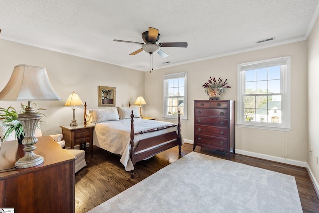 bedroom with multiple windows, ceiling fan, dark hardwood / wood-style flooring, and ornamental molding