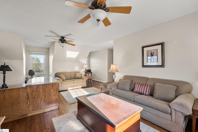 living room with lofted ceiling with skylight and light wood-type flooring