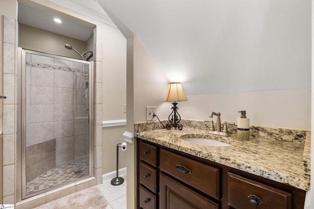 bathroom featuring tile patterned flooring, vanity, walk in shower, and vaulted ceiling