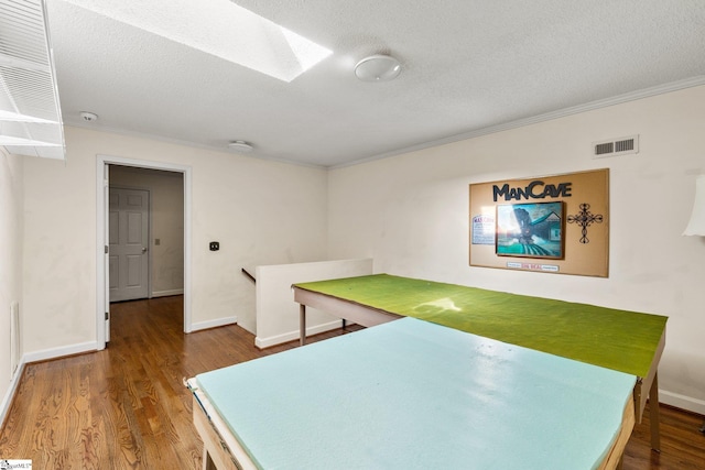 interior space with hardwood / wood-style floors, crown molding, and a textured ceiling