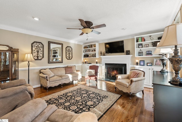 living room with ceiling fan, dark wood-type flooring, built in features, a high end fireplace, and a textured ceiling