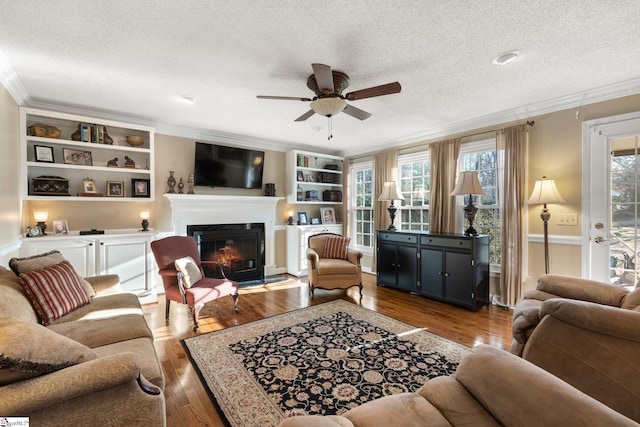 living room with a textured ceiling, dark wood-type flooring, and crown molding