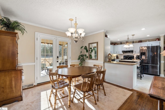 dining space featuring crown molding, french doors, a textured ceiling, and light hardwood / wood-style flooring