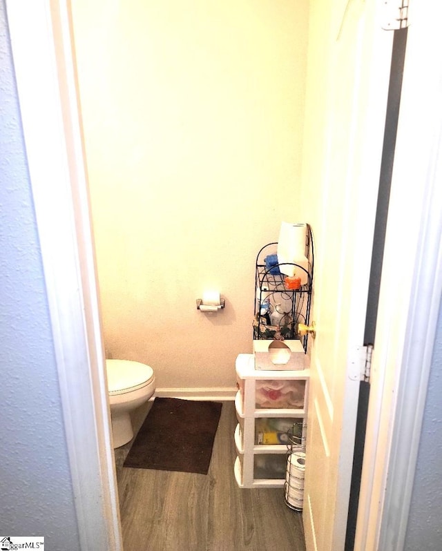 bathroom with hardwood / wood-style floors and toilet