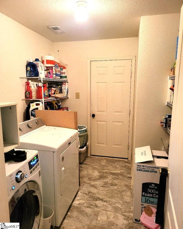 clothes washing area with a textured ceiling and washing machine and dryer