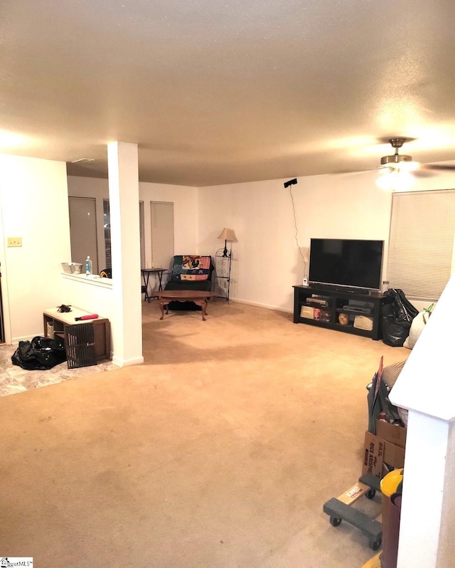 carpeted living room with a textured ceiling and ceiling fan