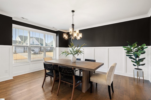 dining room featuring a chandelier, wood-type flooring, and ornamental molding