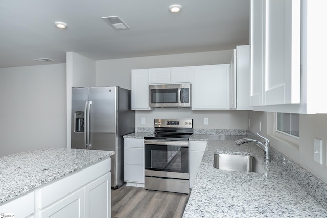 kitchen featuring white cabinets, sink, light stone countertops, and stainless steel appliances